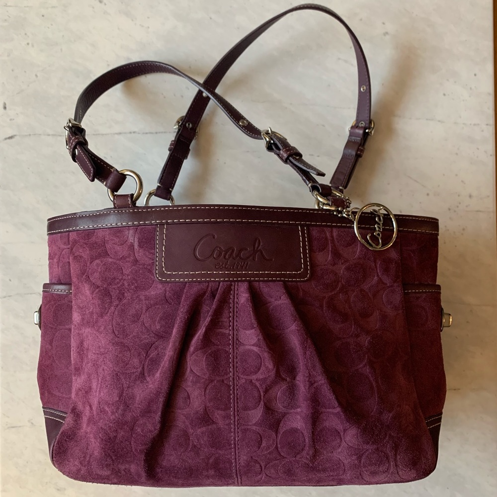 Maroon suede coach shoulder bag with double strap.